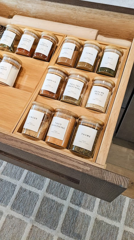glass spice containers with bamboo lid in kitchen drawer with bamboo spice rack