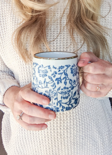 woman holding blue and white coffee mug