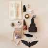 Halloween-themed decorations including a book, candles, and bats on a textured surface.
