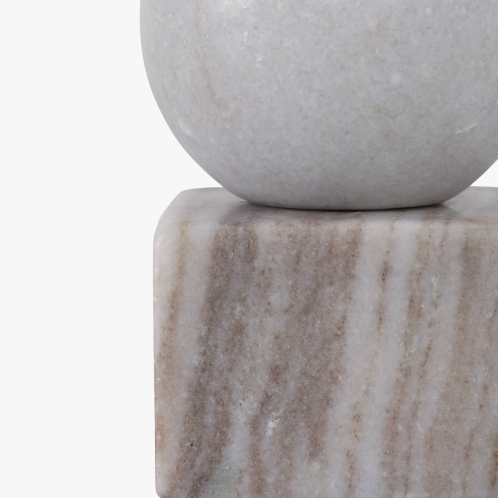 Marble sphere on a rectangular marble block with a plain background