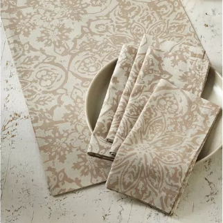 Patterned table runner and napkins on a textured surface with decorative elements.