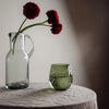 Blown Glass Pitcher used as a vase with flowers on table.