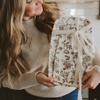 Woman holding a floral-patterned gift box with a bow