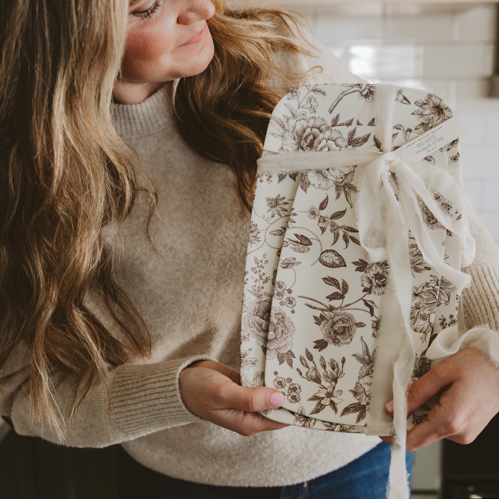 Woman holding a floral-patterned gift box with a bow
