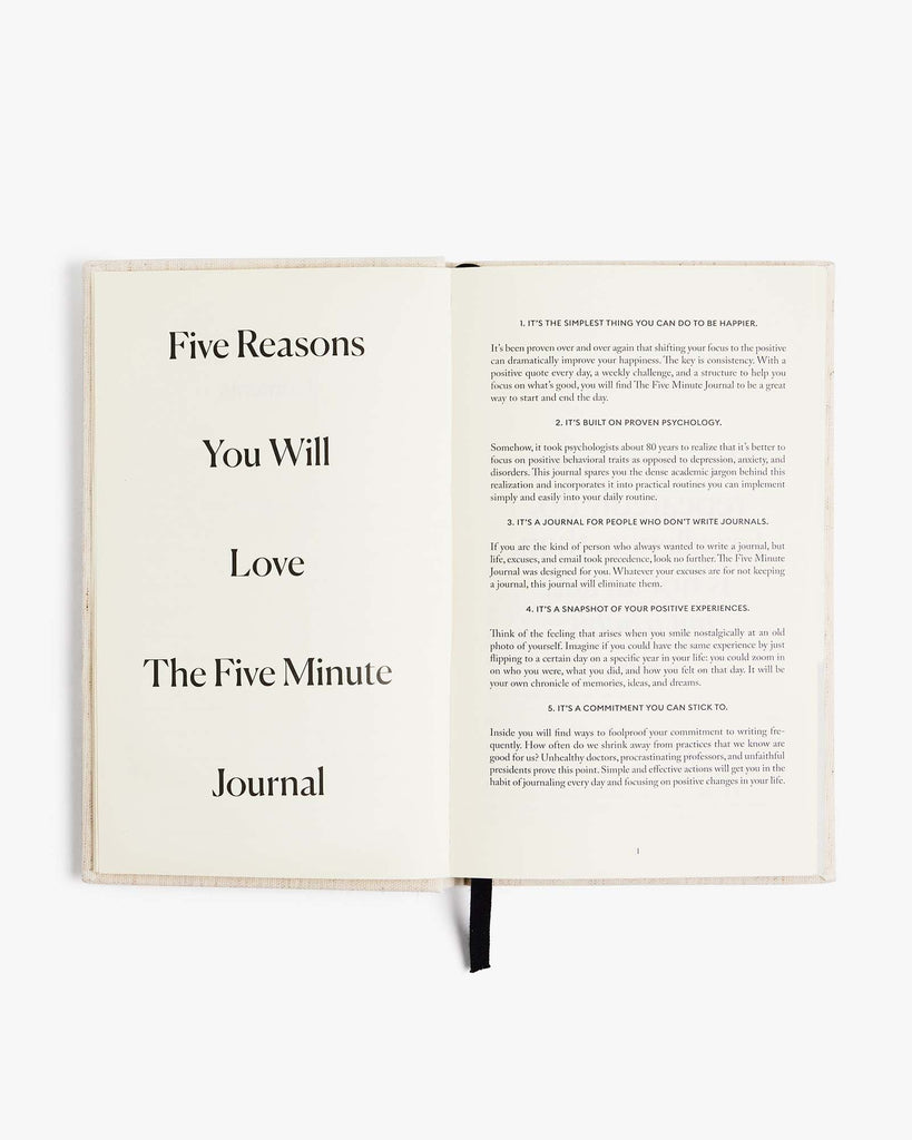 Open book with text about 'The Five Minute Journal' on a white background