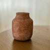 Brown ceramic vase on a wooden surface with a blurred background