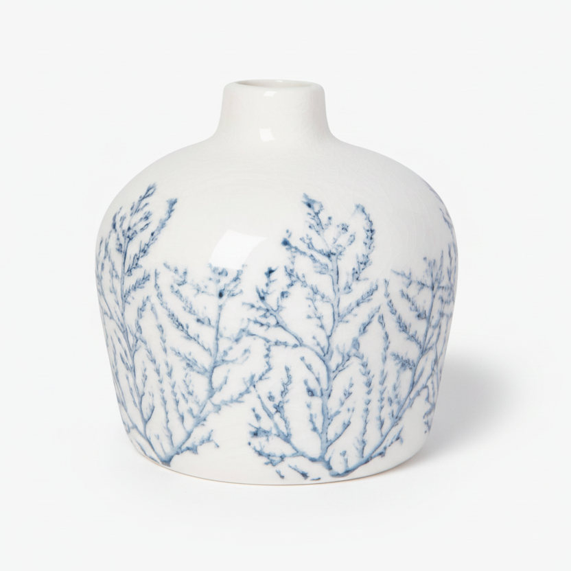 White vase with blue branch-like patterns on a white background