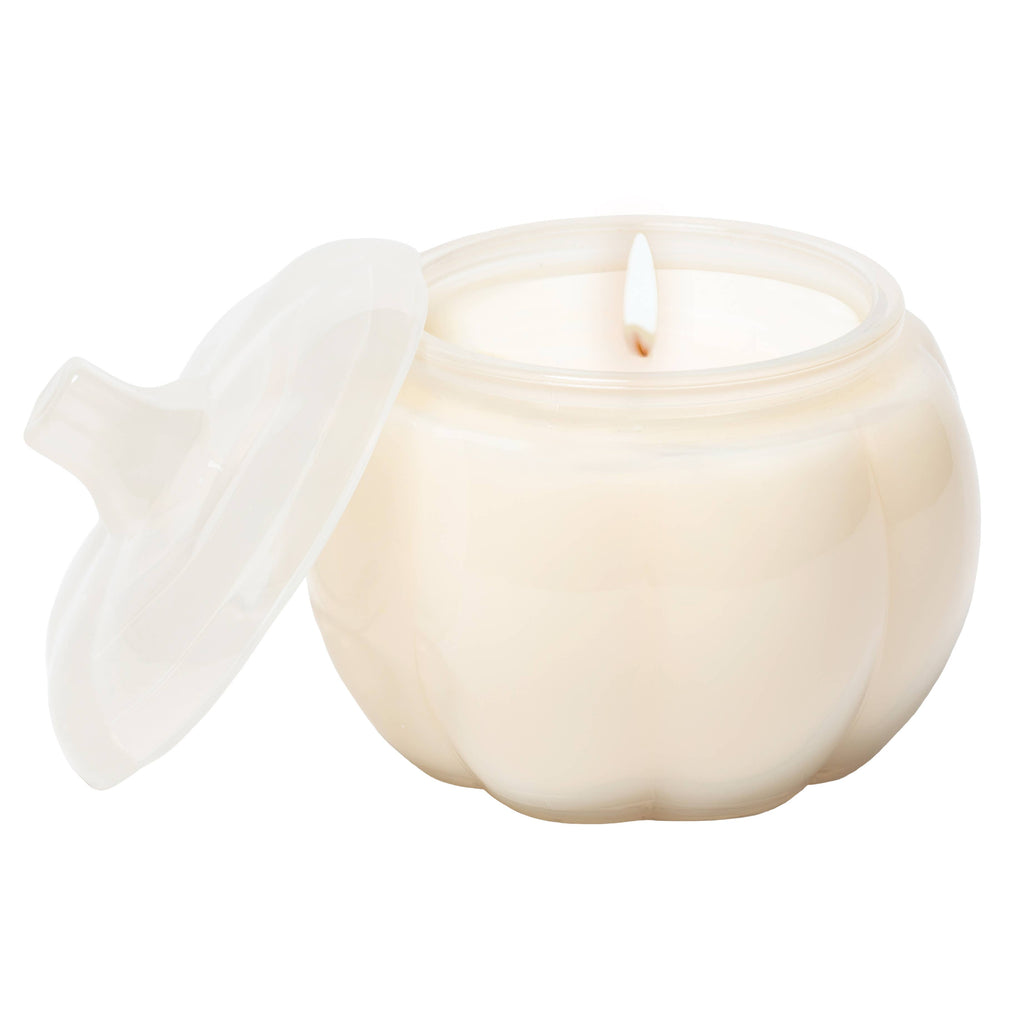 White glass pumpkin candle vessel with a lid and a candle inside on a white background