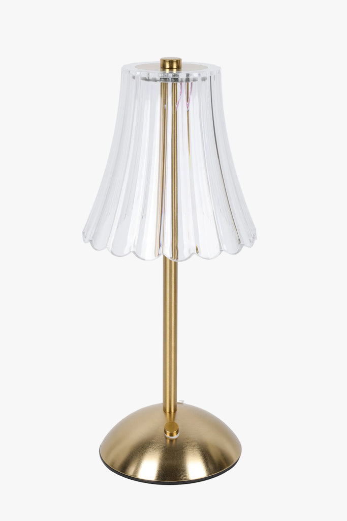 Gold table lamp with a clear glass shade on a white background