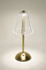 Table lamp with a clear glass shade and brass base on a neutral background
