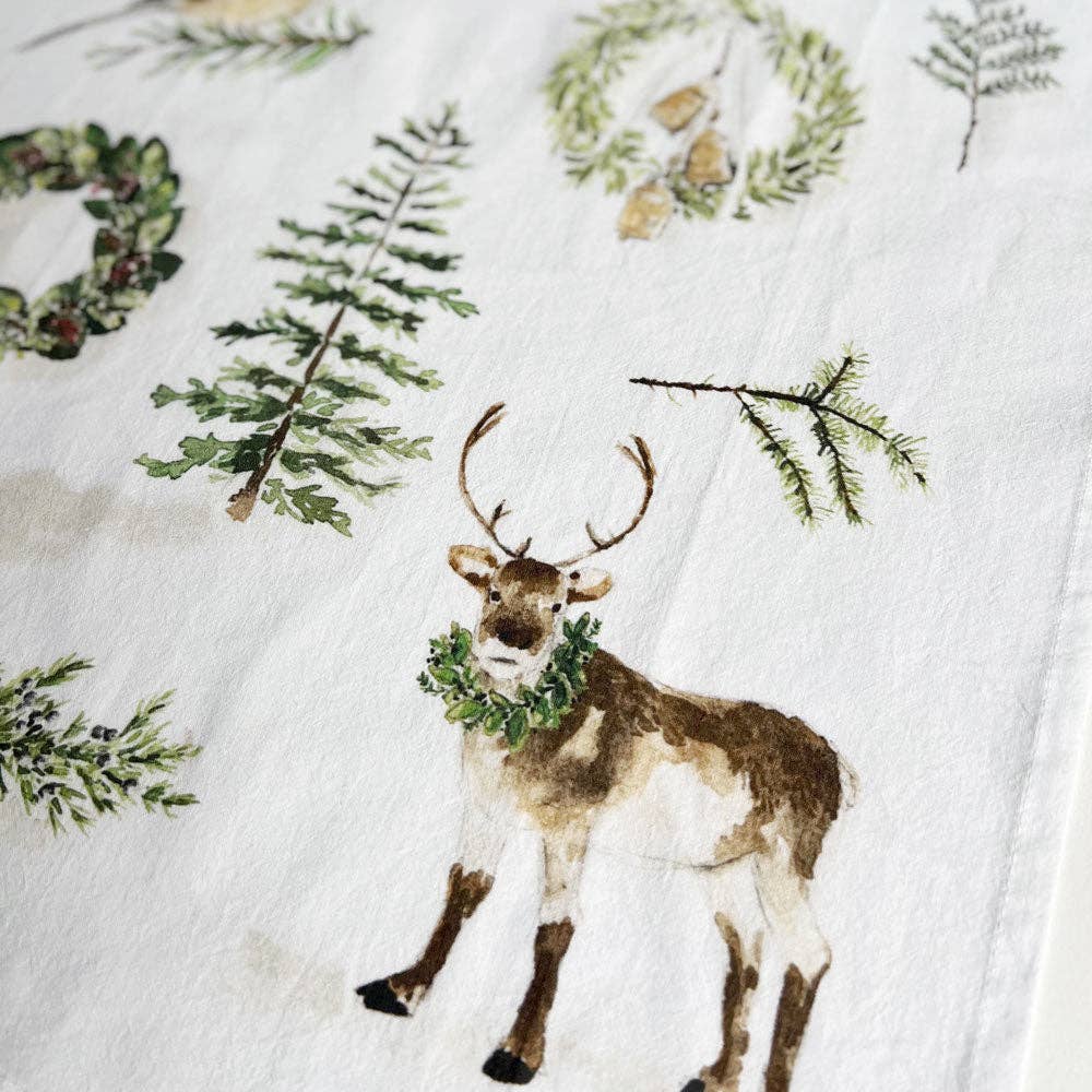 Decorative fabric with a reindeer and greenery design on a white background