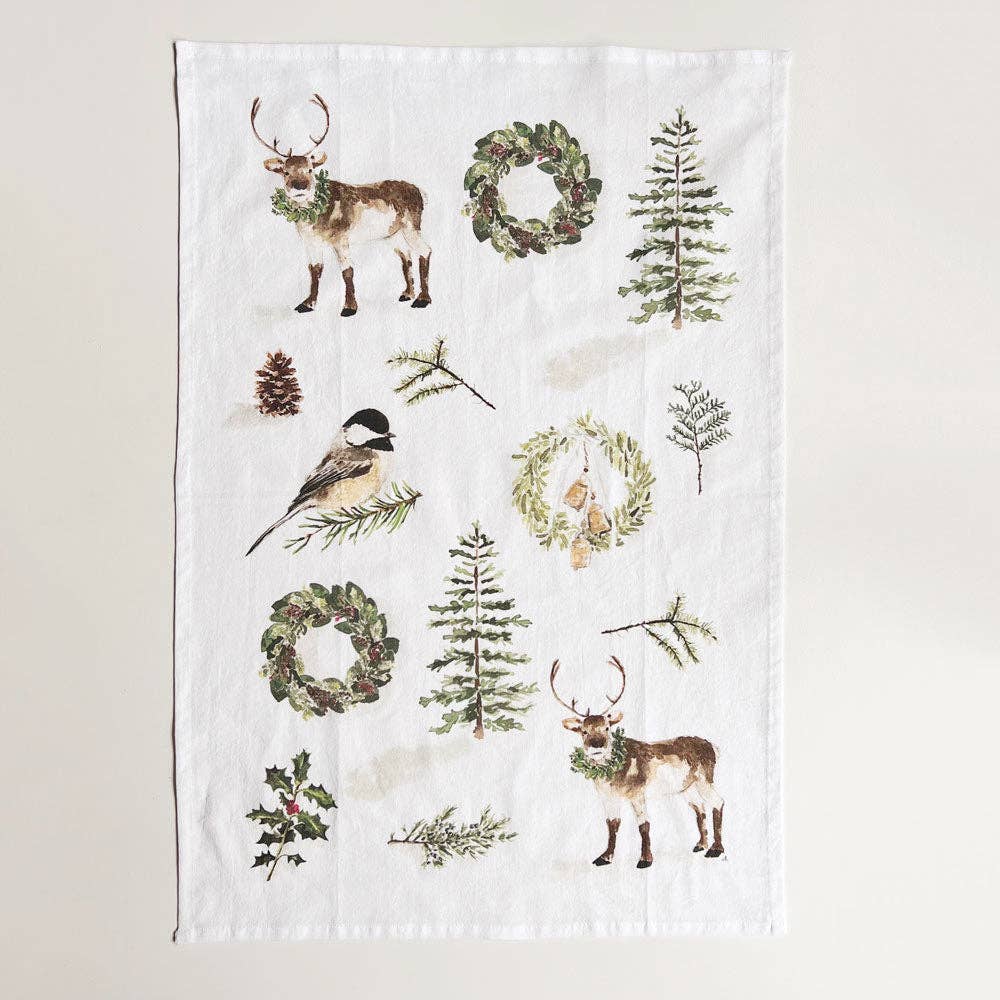 Decorative Christmas Tea towel with nature-themed designs including deer, trees, and wreaths on a white background.