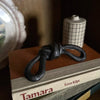 Decorative black knot sculpture on a book with 'Tamara' and 'Eeva Kilpi' visible