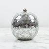 Silver disco ball bottle holder on a marble surface with a white background
