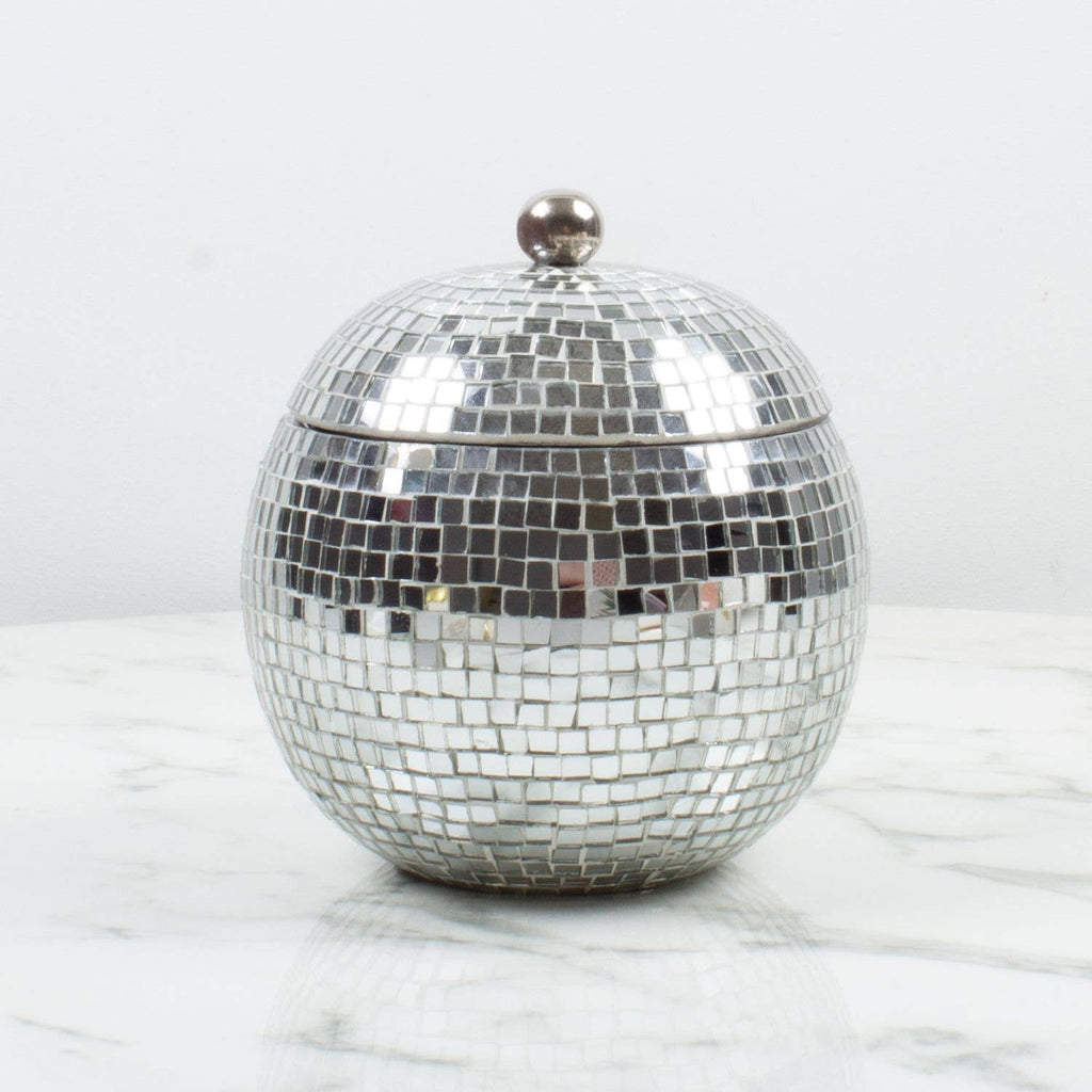 Silver disco ball bottle holder on a marble surface with a white background