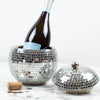 Silver disco ball ice bucket with a bottle of red wine on a white background