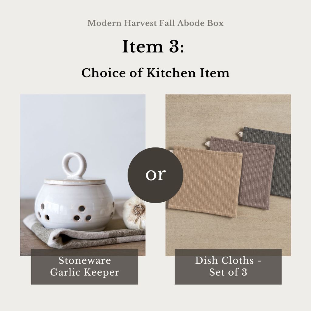 A product selection graphic for the Modern Harvest Fall Abode Box, showing a choice between a Stoneware Garlic Keeper and a Dish Cloth set of 3. The left panel displays a white ceramic garlic keeper with ventilation holes on a neutral background.