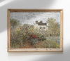 Framed painting of a garden scene with a house and trees on a white wall.