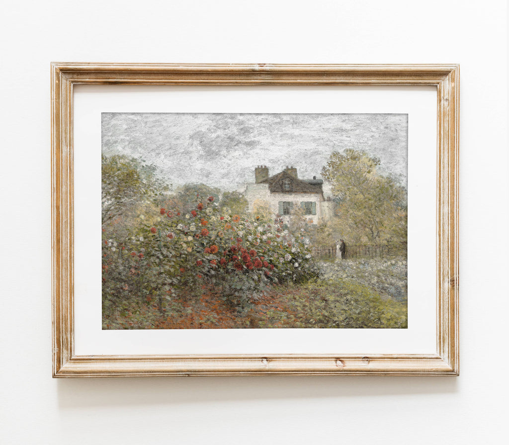 Framed painting of a garden scene with a house and trees on a white wall.