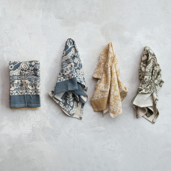 Floral patterned tea towels on a textured gray surface