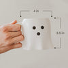 White ghost mug with measurements on a light gray background