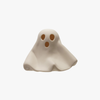A small ghost-shaped decorative object with two circular eye cutouts and one mouth cutout, shown on a plain light gray background.