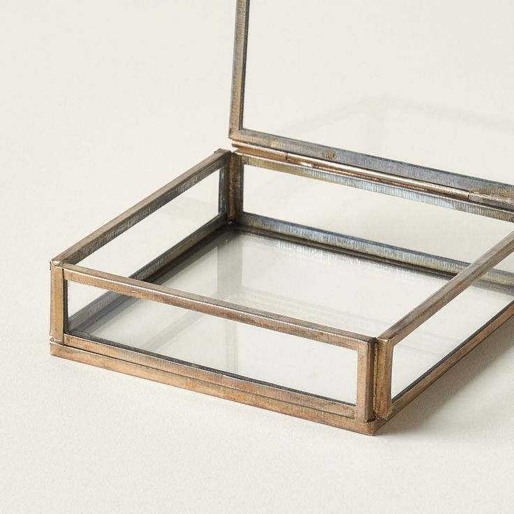 Glass box with brass frame on a light background - organic modern home decor