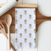Floral patterned towel on a wooden cutting board with wooden utensils