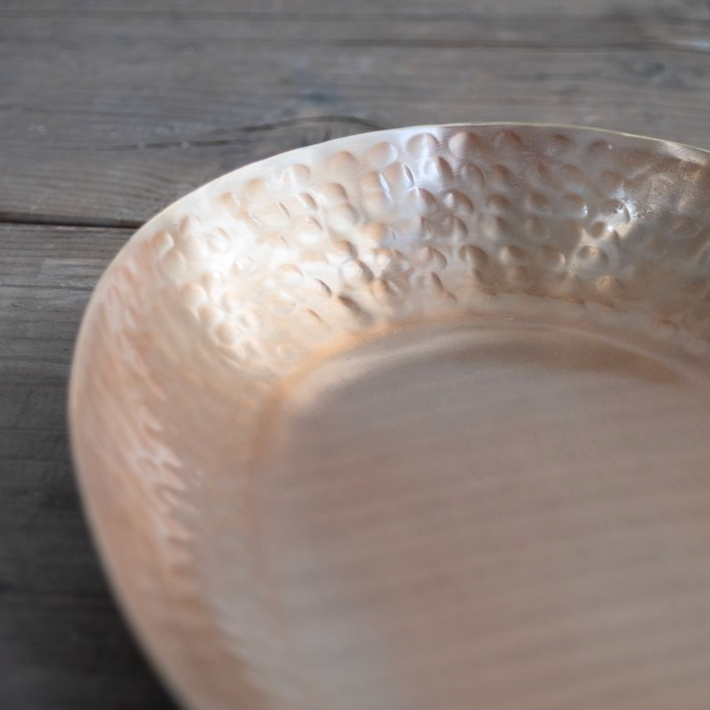 Close-up of a brass tray on a wooden surface