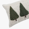 Decorative christmas throw pillow with embroidered green trees on a beige background