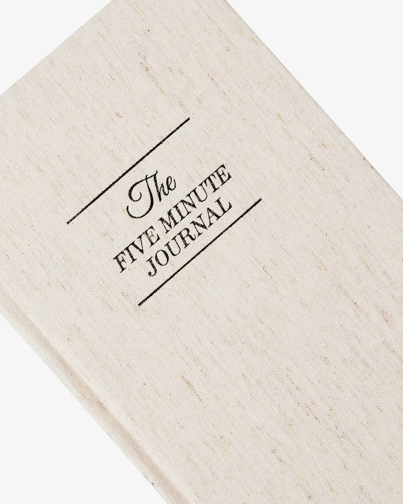 Beige journal with 'The Five Minute Journal' text on a white background