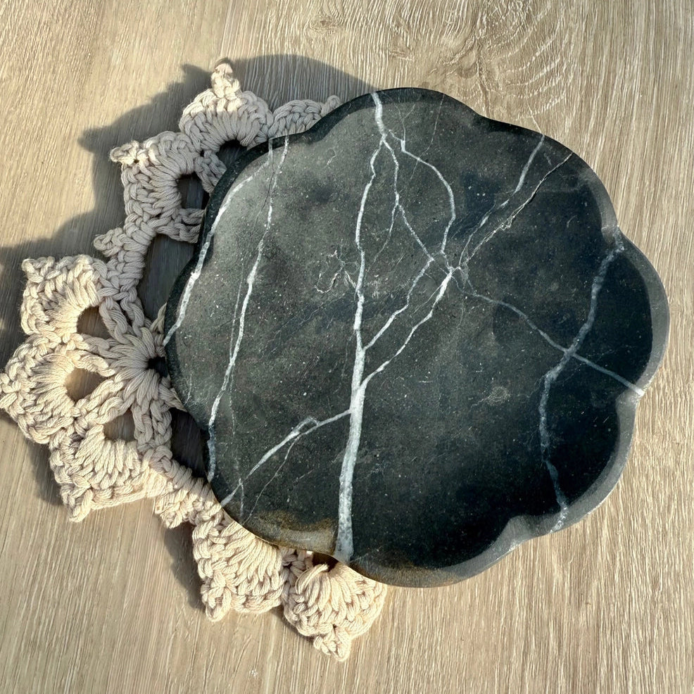 Marble tray on a wooden surface with a crochet doily