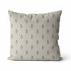 A square throw pillow in a light beige linen fabric with a repeating black floral pattern, shown against a plain white background.
