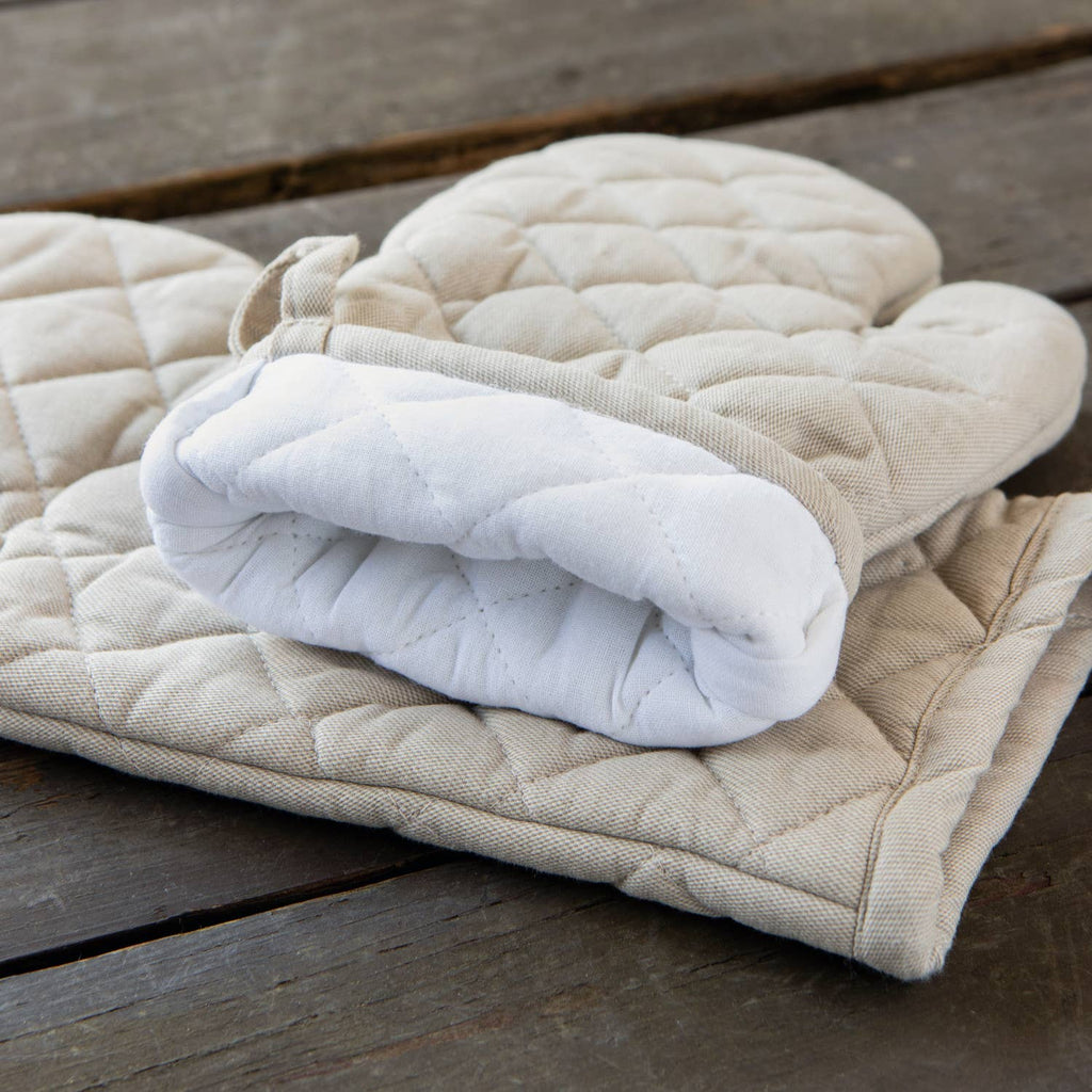 Stack of quilted oven mitts on a wooden surface