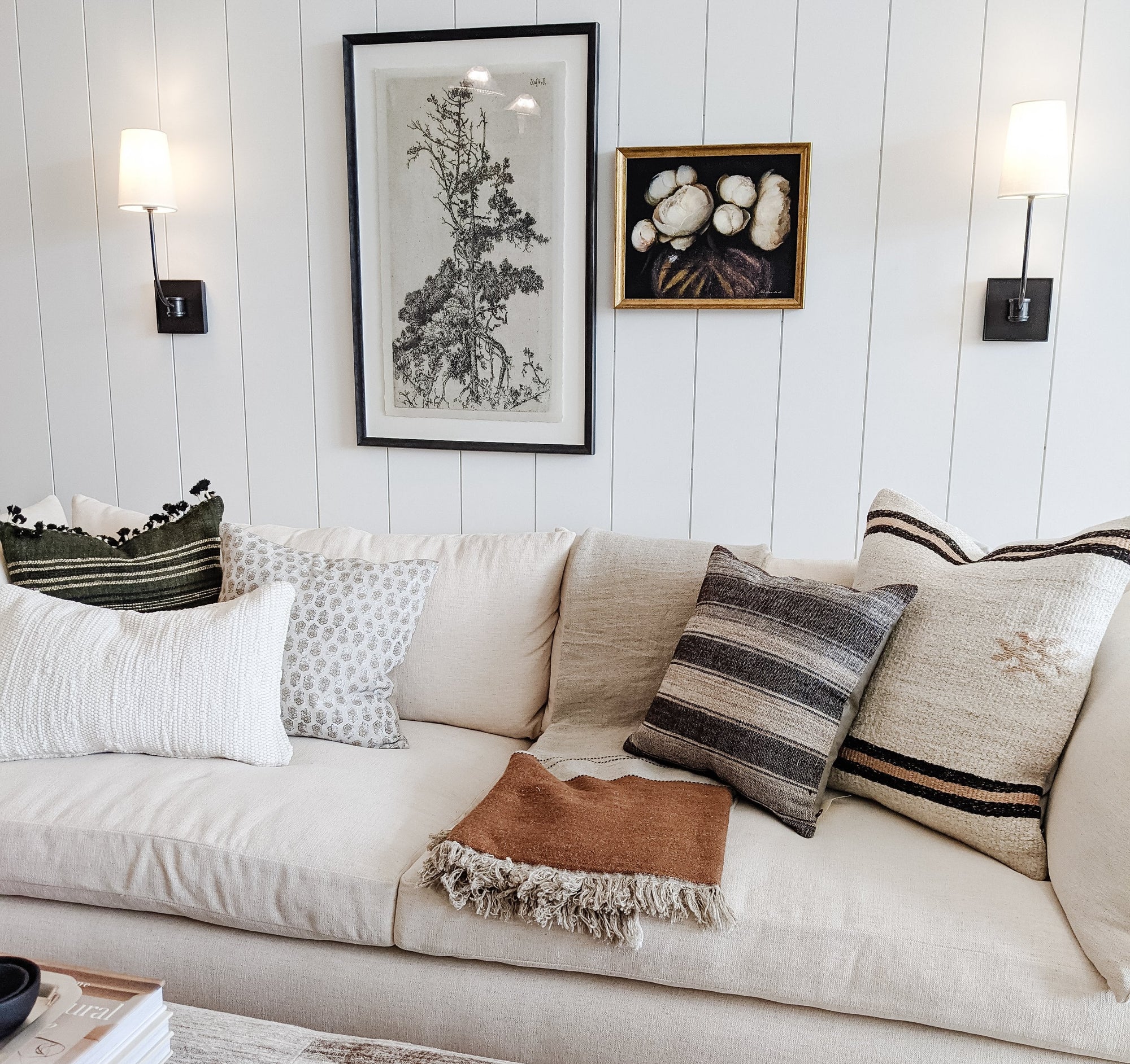 Living room with a beige sofa, decorative pillows, and wall art.