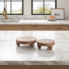 Two wooden risers on a marble countertop in a kitchen.