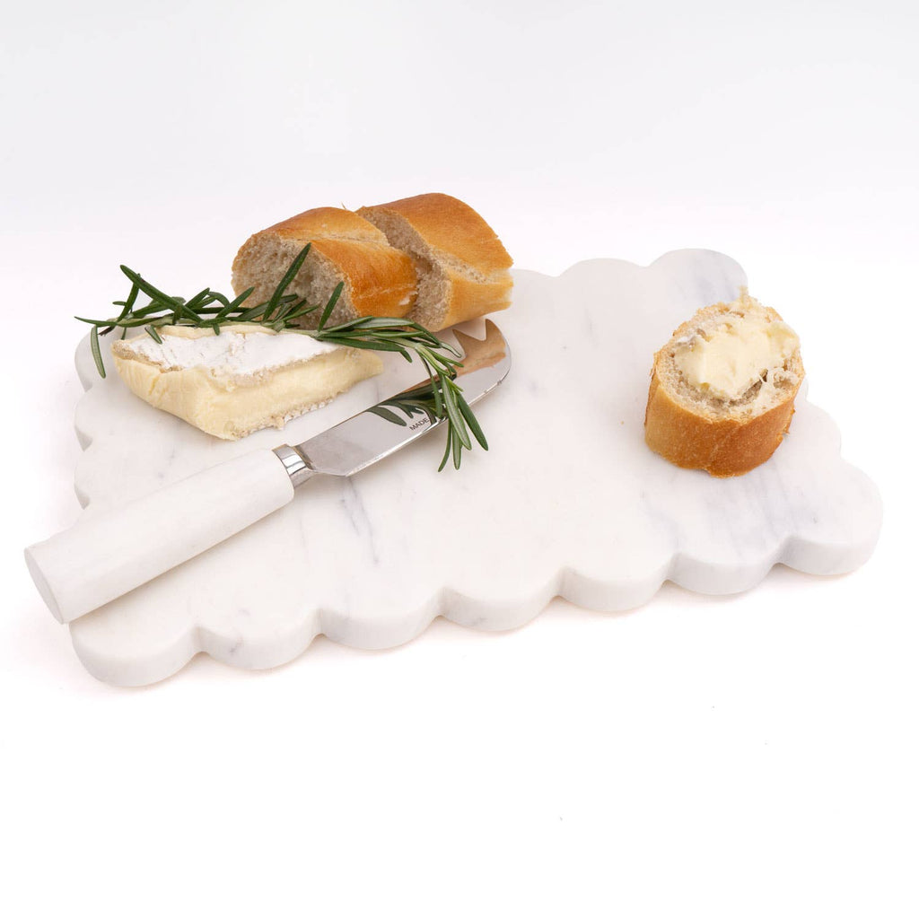 White marble cheese board with bread and cheese on a white background