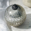 A Mercury Glass Ornament Candle with a silver top and base, featuring a geometric pattern.