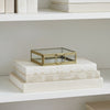 Glass box with brass frame on a striped fabric background