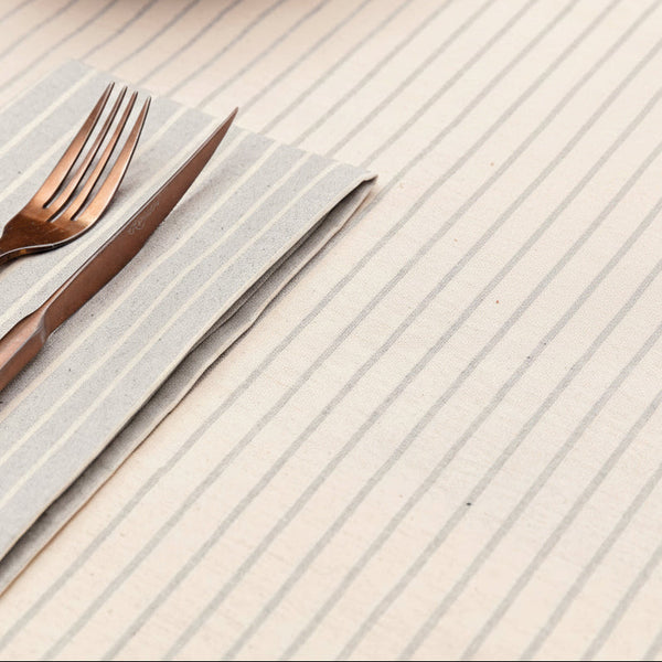 Table setting with a fork and knife on a striped cotton table cloth