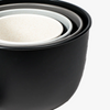 Set of black nesting bowls with white interior on white background