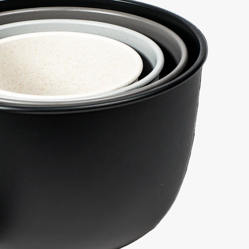 Set of black nesting bowls with white interior on white background