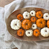 Decorative arrangement of small pumpkins on a brass tray with a neutral background