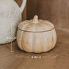 Decorative pumpkin-shaped soy candle with dimensions on a brown surface