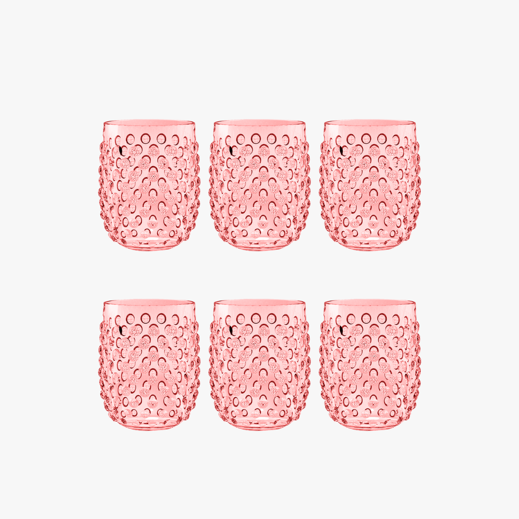 Set of six pink textured stemless wine glasses on a white background
