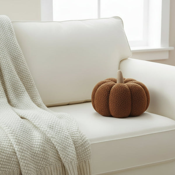 sherpa pumpkin pillow in a warm brown color on a white couch
