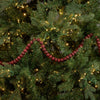 Red bead garland on a decorated Christmas tree with lights