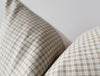 Close-up of a plaid patterned pillow on a neutral background_california casual home decorating