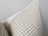 Close-up of a textured pillow with a plaid pattern on a neutral background