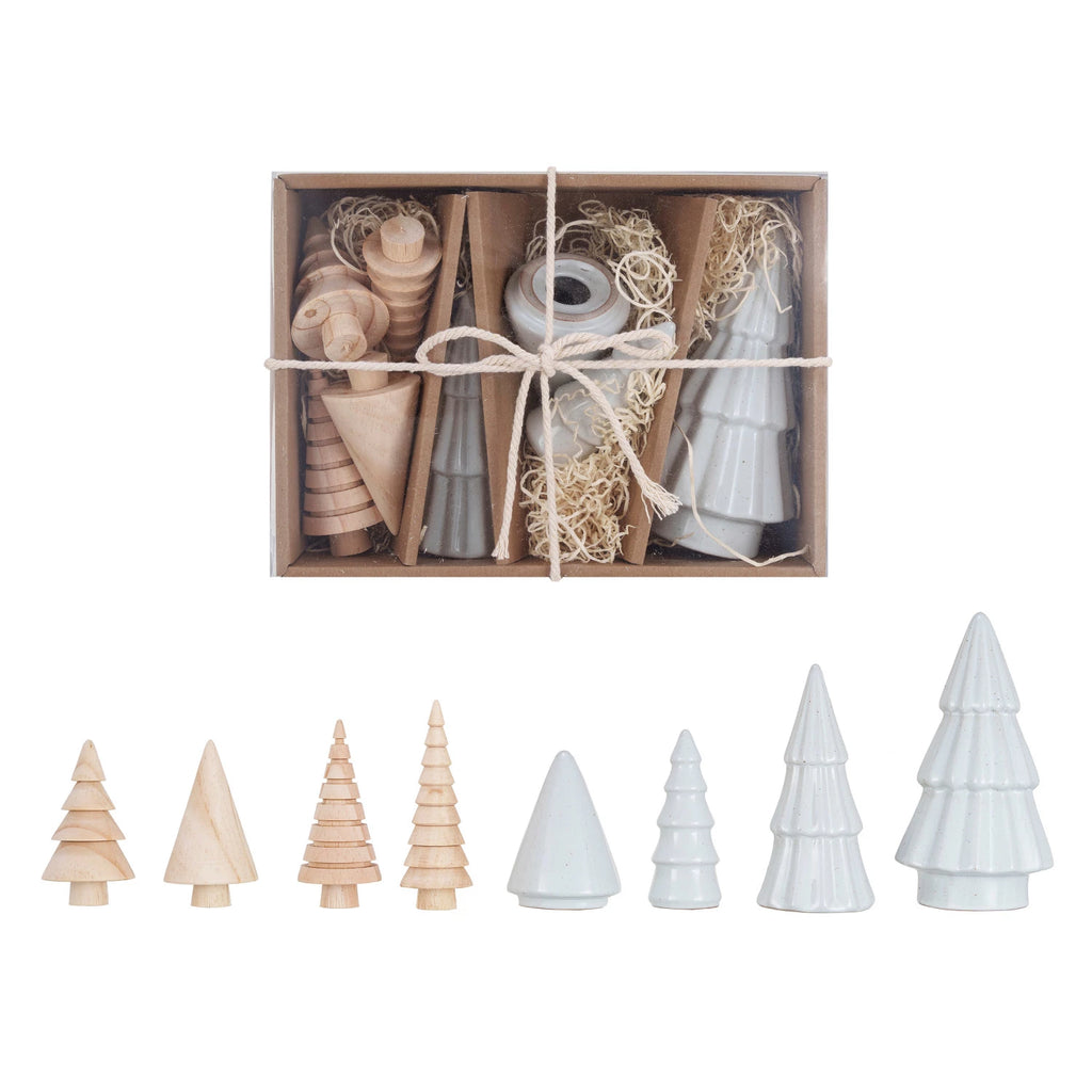 Set of wooden and ceramic Christmas tree figurines in a box on a white background